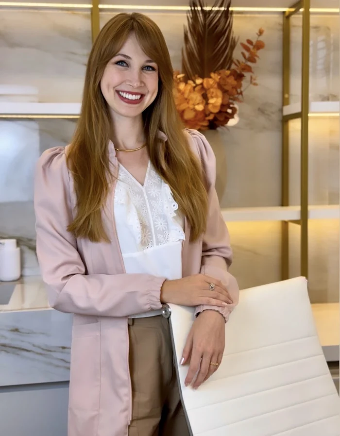 Jaque Schroeder, nutricionista, sorrindo no consultório.